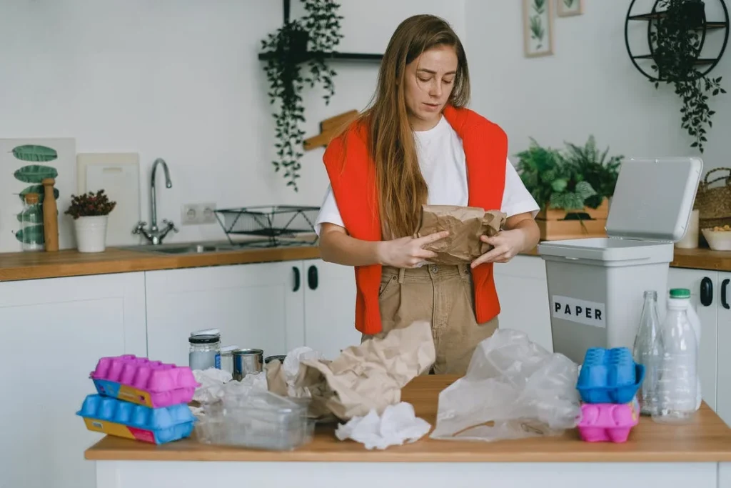 woman sorting trash in the kitchen