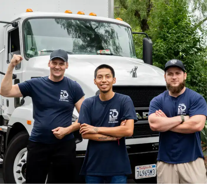 Movers posing in front of a truck